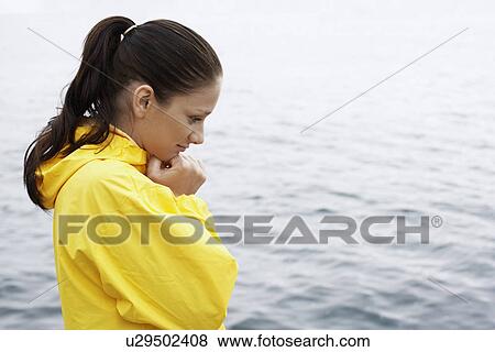 Young woman in yellow raincoat View Large Photo Image Stock Photo - Young woman in yellow raincoat. Fotosearch