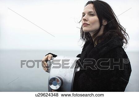 Young woman leaning on coin-operated binoculars View Large Photo Image Stock Photo - Young woman leaning on coin-operated binoculars. Fotosearch