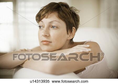 Stock Photography - Mid adult woman leaning on hands. Fotosearch