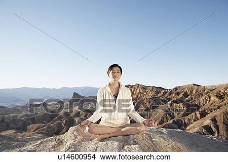 Woman meditating in lotus position in desert, Death Valley, California, USA View Large Photo Image Picture - Woman meditating in lotus position in desert, Death Valley, California, USA. Fotosearch