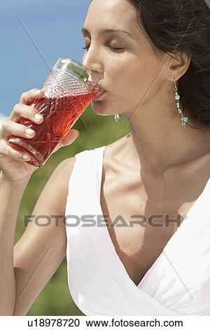 Stock Image - Young woman drinking juice. Fotosearch
