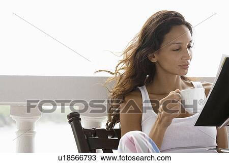 Young woman drinking tea and reading magazine View Large Photo Image Stock Image - Young woman drinking tea and reading magazine. Fotosearch