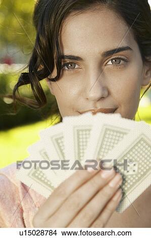 Picture - Young woman holding playing cards. Fotosearch