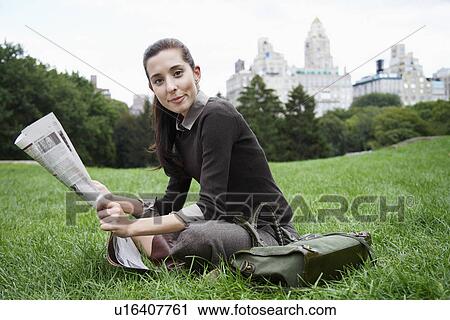 Young woman reading newspaper in park (portrait) View Large Photo Image Stock Image - Young woman reading newspaper in park (portrait). Fotosearch