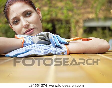 Young woman wearing garden gloves (portrait) View Large Photo Image Picture - Young woman wearing garden gloves (portrait). Fotosearch