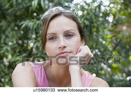 Stock Image - Young woman with chin on hands (portrait). Fotosearch