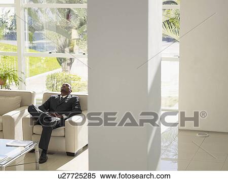 Businessman sleeping on armchair in lobby (high angle view) View Large Photo Image Stock Photography - Businessman sleeping on armchair in lobby (high angle view). Fotosearch