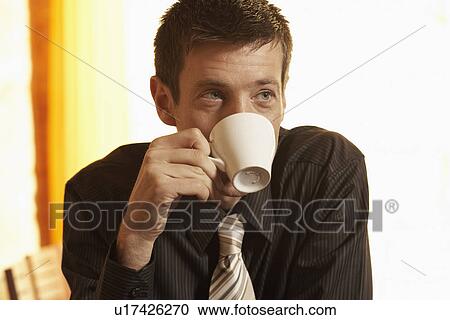 Mid adult businessman drinking coffee View Large Photo Image Stock Image - Mid adult businessman drinking coffee. Fotosearch