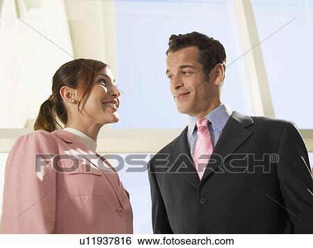Businesswoman and businessman looking each other (low angle view) View Large Photo Image Stock Photograph - Businesswoman and businessman looking each other (low angle view). Fotosearch