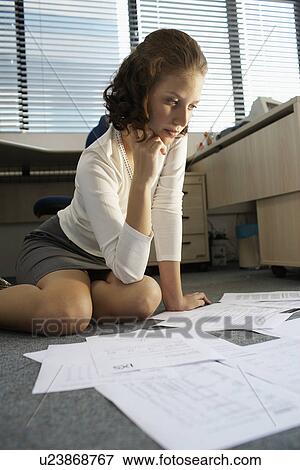 Businesswoman doing paper work on floor (low angle view) View Large Photo Image Stock Photo - Businesswoman doing paper work on floor (low angle view). Fotosearch