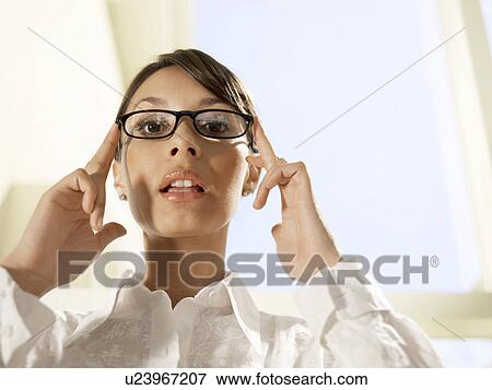 Businesswoman holding eyeglasses on her face View Large Photo Image Stock Photo - Businesswoman holding eyeglasses on her face. Fotosearch