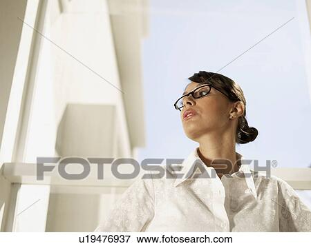 Businesswoman near window (low angle view) View Large Photo Image Stock Photo - Businesswoman near window (low angle view). Fotosearch
