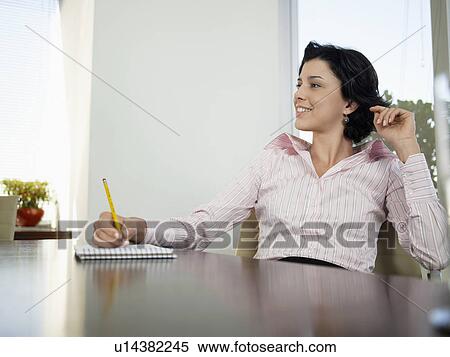 Businesswoman writing on notepad in meeting View Large Photo Image Stock Photography - Businesswoman writing on notepad in meeting. Fotosearch