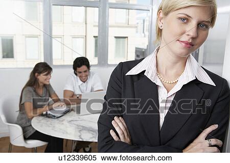 Female manager, colleagues using laptop in background (portrait) View Large Photo Image Stock Photography - Female manager, colleagues using laptop in background (portrait). Fotosearch