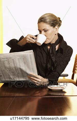 Mid adult woman drinking coffee and reading newspaper View Large Photo Image Stock Photography - Mid adult woman drinking coffee and reading newspaper. Fotosearch