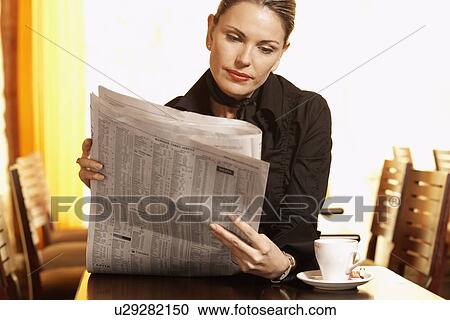 Mid adult woman reading newspaper in cafe View Large Photo Image Stock Image - Mid adult woman reading newspaper in cafe. Fotosearch