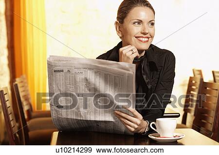 Mid adult woman reading newspaper in cafe View Large Photo Image Stock Photo - Mid adult woman reading newspaper in cafe. Fotosearch