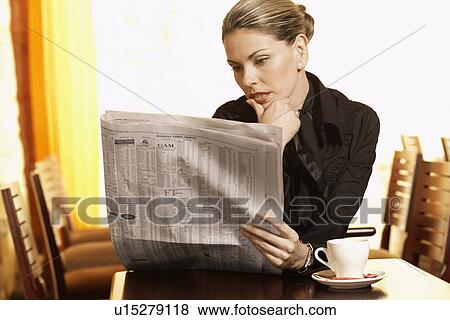 Mid adult woman reading newspaper in cafe View Large Photo Image Stock Photo - Mid adult woman reading newspaper in cafe. Fotosearch