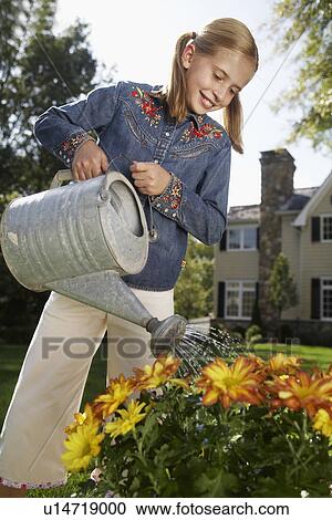 Girl (10-11) watering flowers, Chatham, New Jersey, USA View Large Photo Image Stock Image - Girl (10-11) watering flowers, Chatham, New Jersey, USA. Fotosearch