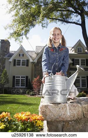 Girl (10-11) with watering can standing by flower bed, Chatham, New Jersey, USA View Large Photo Image Stock Photo - Girl (10-11) with watering can standing by flower bed, Chatham, New Jersey, USA. Fotosearch