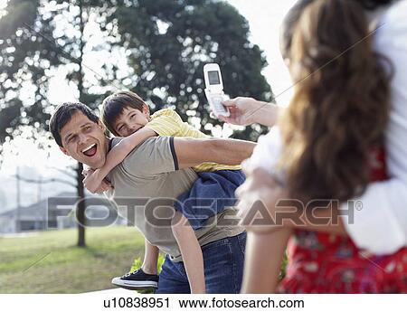 Mother and daughter photographing father and son View Large Photo Image Stock Image - Mother and daughter photographing father and son. Fotosearch