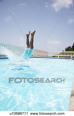 Mid adult man diving into swimming pool View Large Photo Image Stock Image - Mid adult man diving into swimming pool. Fotosearch