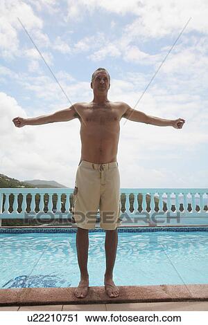 Mid adult man with arms outstretched standing pool View Large Photo Image Stock Image - Mid adult man with arms outstretched standing pool. Fotosearch