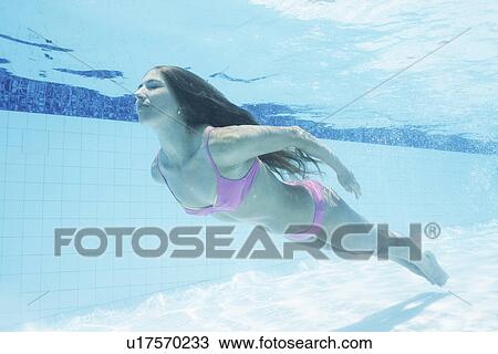 Mid adult woman diving in swimming pool (underwater view) View Large Photo Image Stock Image - Mid adult woman diving in swimming pool (underwater view). Fotosearch