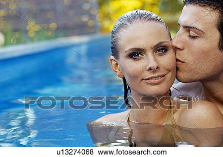 Stock Photo - Young Couple in Swimming Pool. Fotosearch