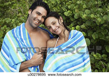 Stock Photography - Young couple wrapped in towel (portrait). Fotosearch