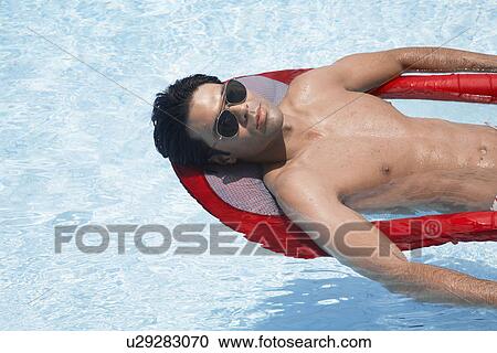 Young man lying on pool raft View Large Photo Image Stock Image - Young man lying on pool raft. Fotosearch