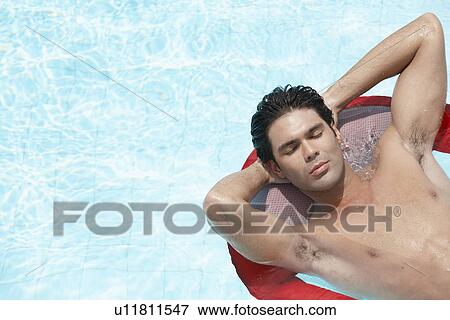 Young man sleeping on inflatable mattress in swimming pool View Large Photo Image Stock Photo - Young man sleeping on inflatable mattress in swimming pool. Fotosearch