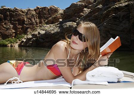Young woman reading book on motorboat View Large Photo Image Stock Photography - Young woman reading book on motorboat. Fotosearch