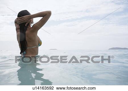 Young woman standing in water at dusk, St. John, US Virgin Islands, USA View Large Photo Image Stock Image - Young woman standing in water at dusk, St. John, US Virgin Islands, USA. Fotosearch