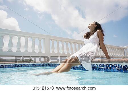Young woman sunbathing by pool View Large Photo Image Stock Image - Young woman sunbathing by pool. Fotosearch