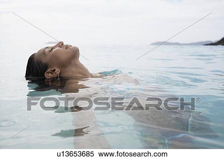 Young woman swimming in water View Large Photo Image Stock Photography - Young woman swimming in water. Fotosearch