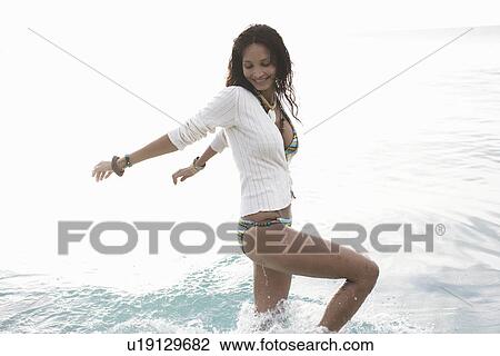 Young woman walking in water View Large Photo Image Stock Image - Young woman walking in water. Fotosearch