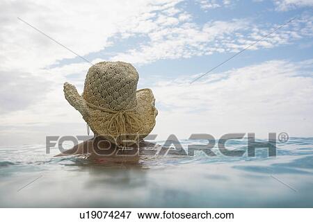 Young woman wearing hat and swimming View Large Photo Image Stock Photo - Young woman wearing hat and swimming. Fotosearch