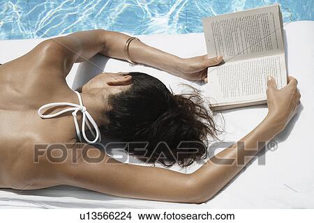 Young woman with book sleeping by pool View Large Photo Image Picture - Young woman with book sleeping by pool. Fotosearch