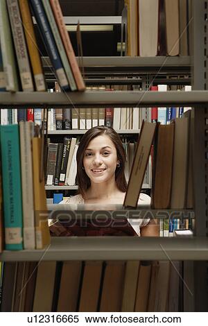 Student behind bookcase in library (portrait) View Large Photo Image Stock Photography - Student behind bookcase in library (portrait). Fotosearch
