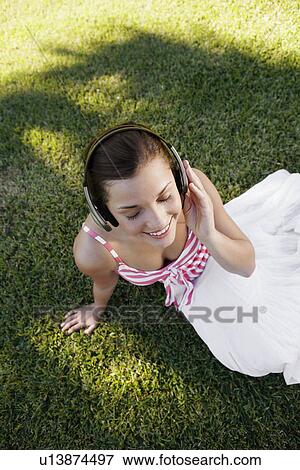 Stock Photo - Teenage girl listening to headphones (high angle view). Fotosearch