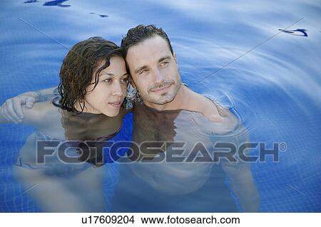 Picture - Mid adult couple in water (portrait, high angle view). Fotosearch