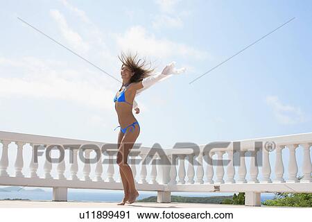 Mid adult woman jumping on balcony View Large Photo Image Stock Image - Mid adult woman jumping on balcony. Fotosearch