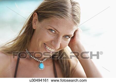Stock Image - Mid adult woman looking down. Fotosearch