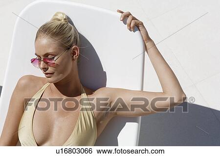 Stock Photograph - Woman sunbathing (high angle view). Fotosearch