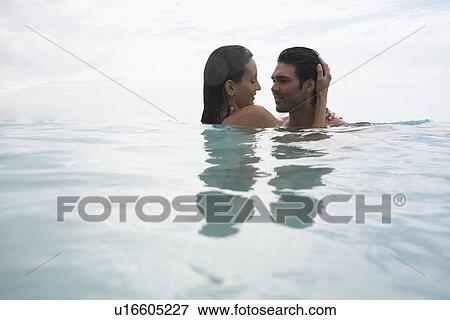Stock Photo - Young couple hugging in water (low angle view), St. John, US Virgin Islands, USA. Fotosearch