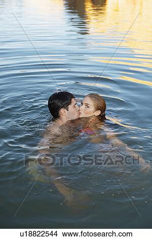 Young couple kissing in water View Large Photo Image Picture - Young couple kissing in water. Fotosearch