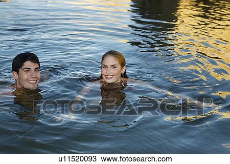 Young couple swimming in lake View Large Photo Image Stock Image - Young couple swimming in lake. Fotosearch