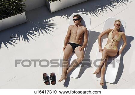 Young man and woman sunbathing (high angle view) View Large Photo Image Stock Image - Young man and woman sunbathing (high angle view). Fotosearch