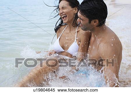 Young man carrying girlfriend in ocean View Large Photo Image Stock Photography - Young man carrying girlfriend in ocean. Fotosearch